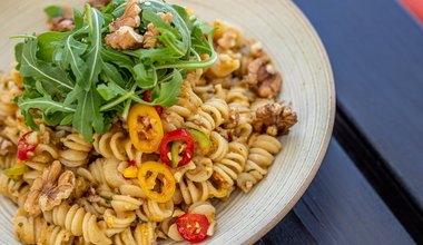 Fusilli-Nudeln mit Walnüssen, Chili und Rucola, serviert auf einem hellen Teller als mediterranes Pastagericht.